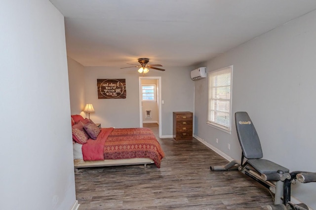 bedroom featuring wood-type flooring, an AC wall unit, and ceiling fan