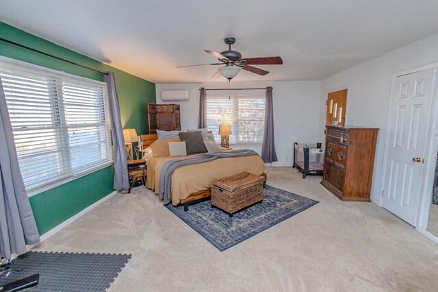 bedroom featuring ceiling fan, a wall mounted AC, and light carpet