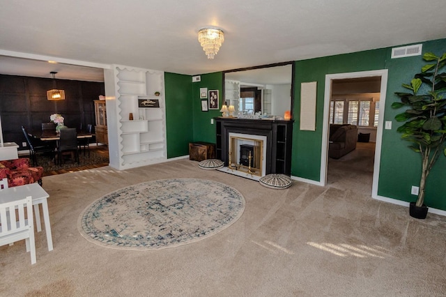 carpeted living room featuring a chandelier