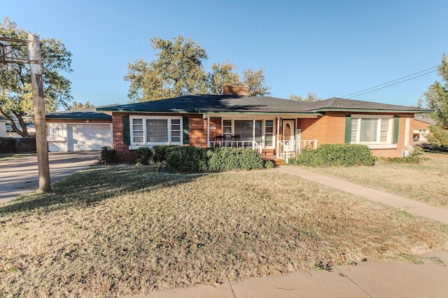 single story home featuring a garage, covered porch, and a front yard