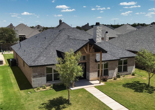 view of front facade featuring central AC unit, a patio area, and a front yard