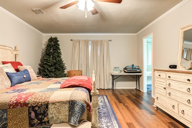 bedroom with crown molding, dark hardwood / wood-style floors, and ceiling fan