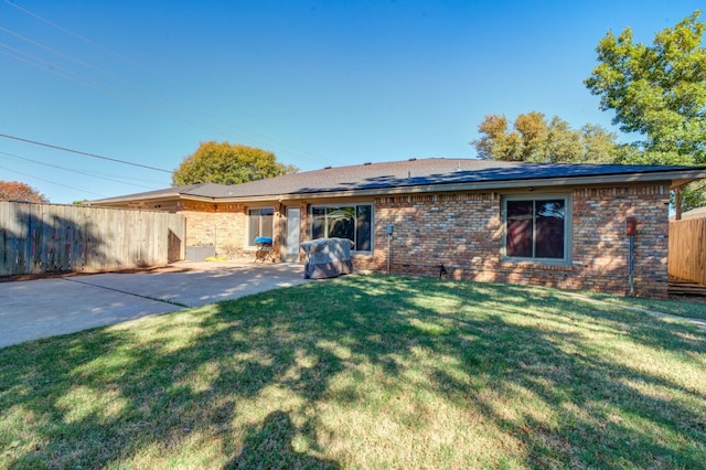 back of property with a yard and a patio area