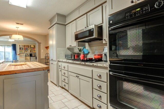 kitchen with ceiling fan, tasteful backsplash, black appliances, wood counters, and decorative light fixtures