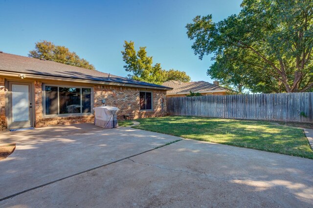 back of property featuring a yard and a patio