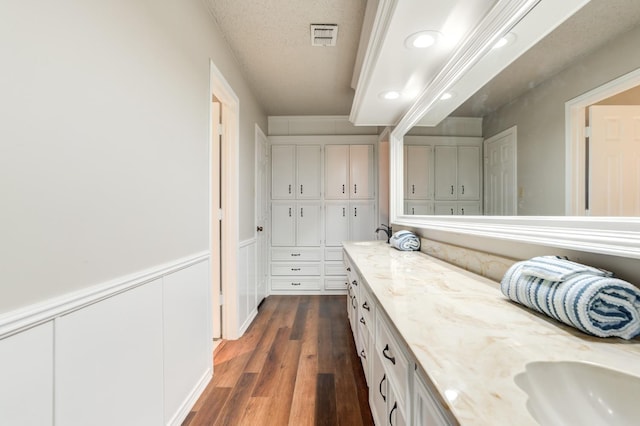 bathroom with hardwood / wood-style flooring and a textured ceiling