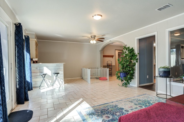 living room featuring crown molding and ceiling fan