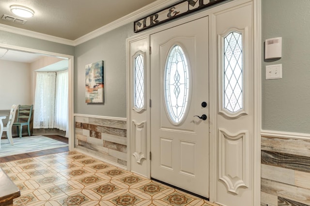 foyer entrance with crown molding and a textured ceiling