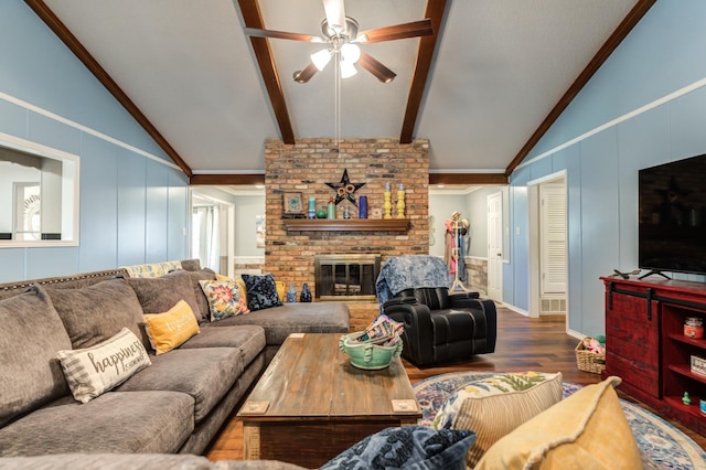 living room with a fireplace, wood-type flooring, vaulted ceiling with beams, ceiling fan, and crown molding