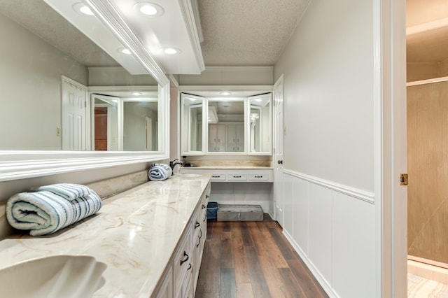 bathroom featuring wood-type flooring, vanity, and a textured ceiling