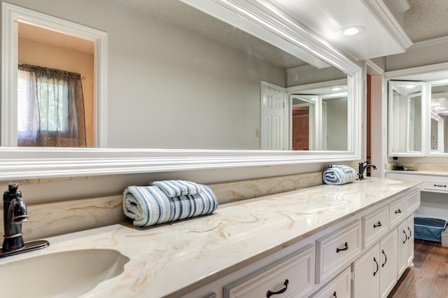 bathroom featuring hardwood / wood-style flooring, vanity, and crown molding