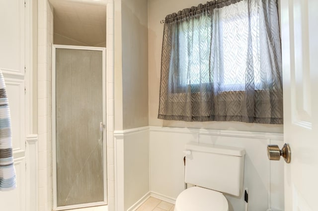 bathroom featuring toilet and a shower with door