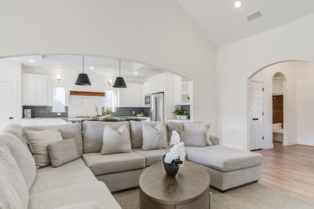 living room featuring light hardwood / wood-style floors and high vaulted ceiling