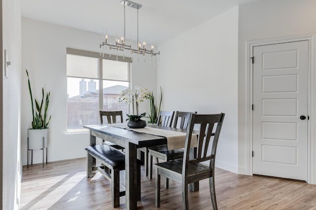 dining area with a notable chandelier and light hardwood / wood-style flooring