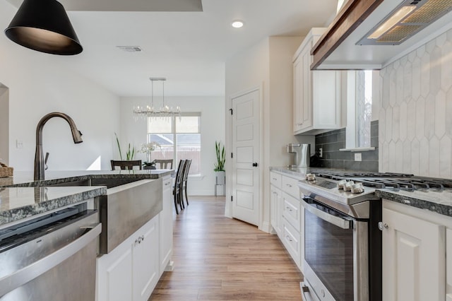 kitchen featuring custom exhaust hood, tasteful backsplash, appliances with stainless steel finishes, dark stone counters, and white cabinets