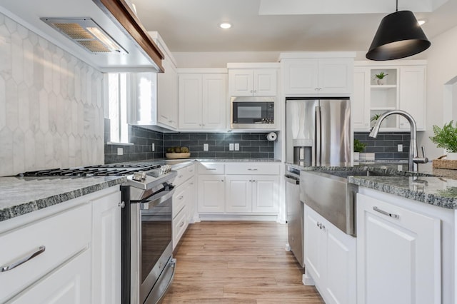 kitchen featuring hanging light fixtures, appliances with stainless steel finishes, white cabinets, and light stone counters