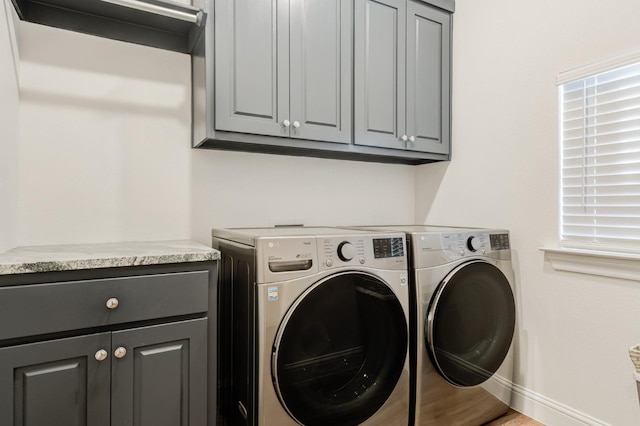 laundry area featuring washing machine and dryer and cabinets