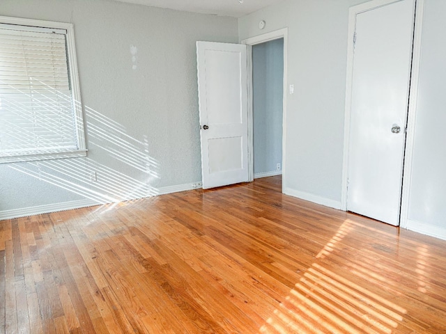 unfurnished bedroom with hardwood / wood-style floors and a closet