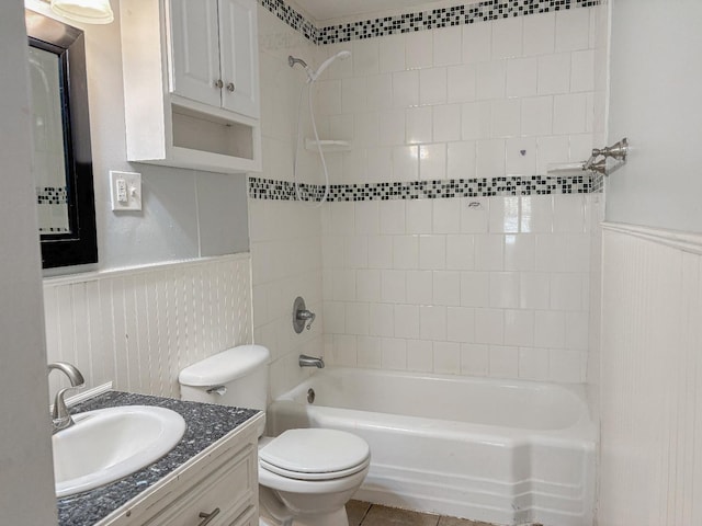 full bathroom featuring tile patterned flooring, vanity, tiled shower / bath, and toilet