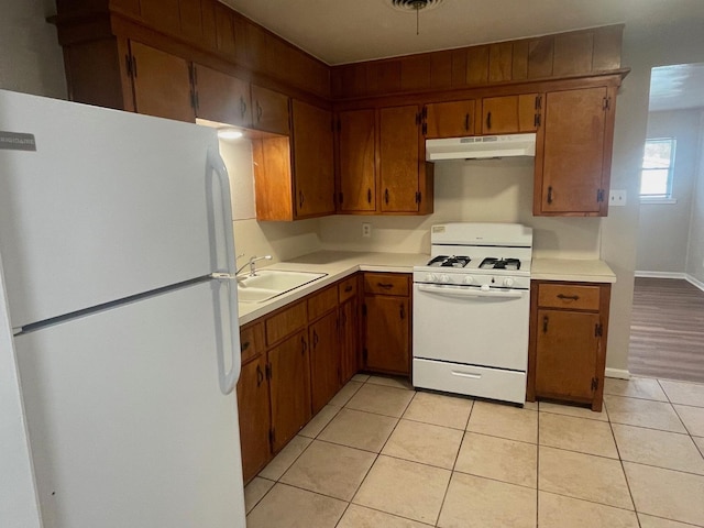 kitchen featuring white appliances, sink, and light tile patterned floors