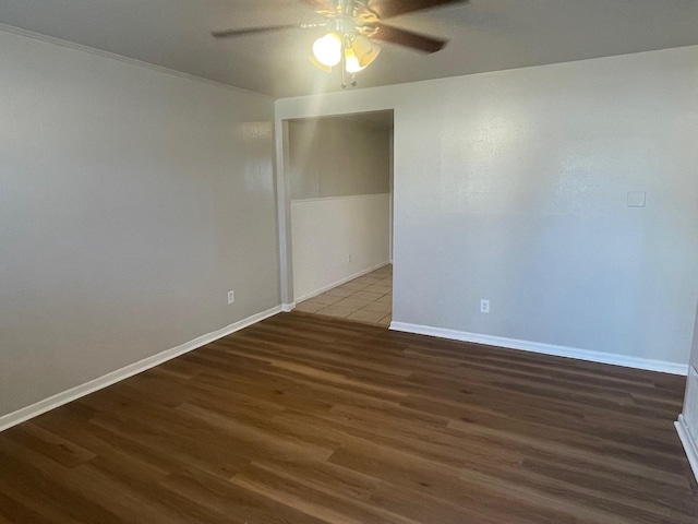 spare room featuring dark wood-type flooring and ceiling fan