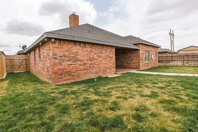 208 Berkshire Ave, Wolfforth, TX 79382 - back of property featuring a lawn, brick siding, and a fenced backyard