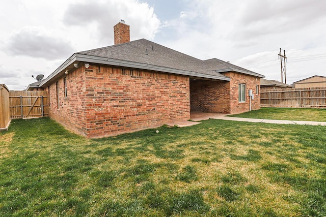 208 Berkshire Ave, Wolfforth, TX 79382 - back of house featuring a lawn, brick siding, a chimney, and a fenced backyard