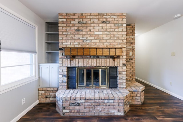 5418 15th St, Lubbock, TX 79416 - unfurnished living room featuring a brick fireplace, wood finished floors, and built in features