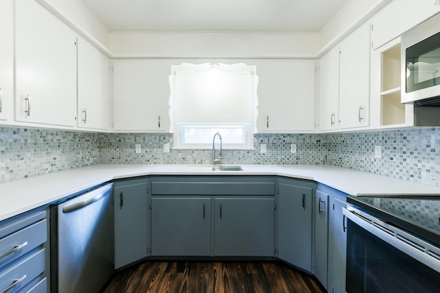 5418 15th St, Lubbock, TX 79416 - kitchen featuring stainless steel appliances, dark wood-style flooring, tasteful backsplash, light countertops, and white cabinets