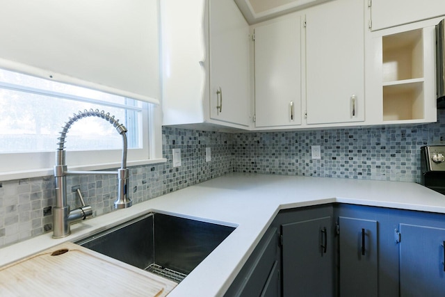 5418 15th St, Lubbock, TX 79416 - kitchen featuring backsplash, open shelves, light countertops, and white cabinets