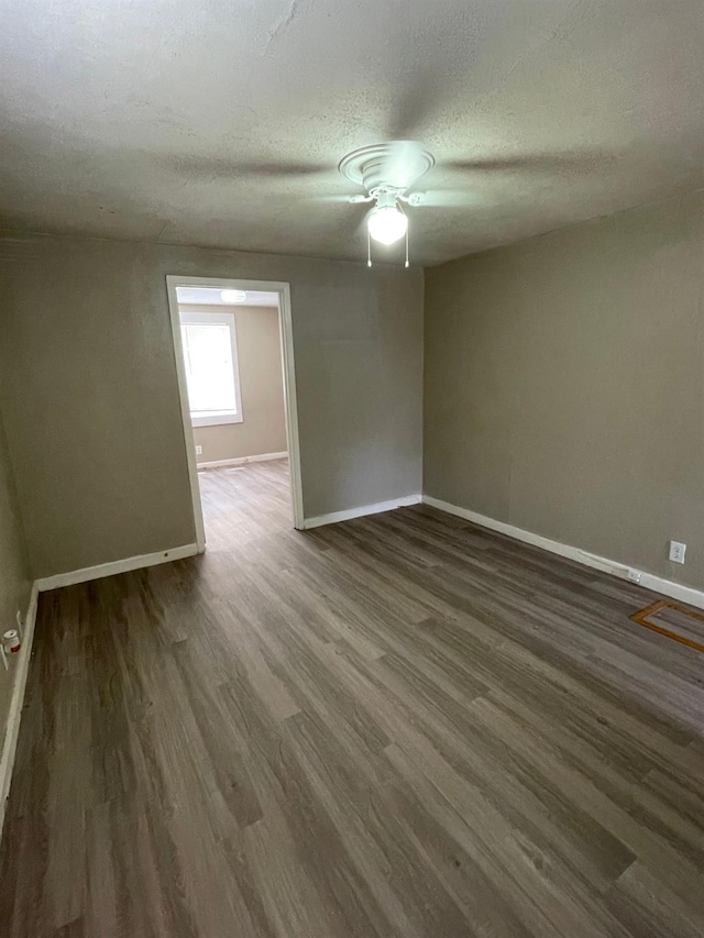 empty room featuring dark wood-type flooring and a textured ceiling