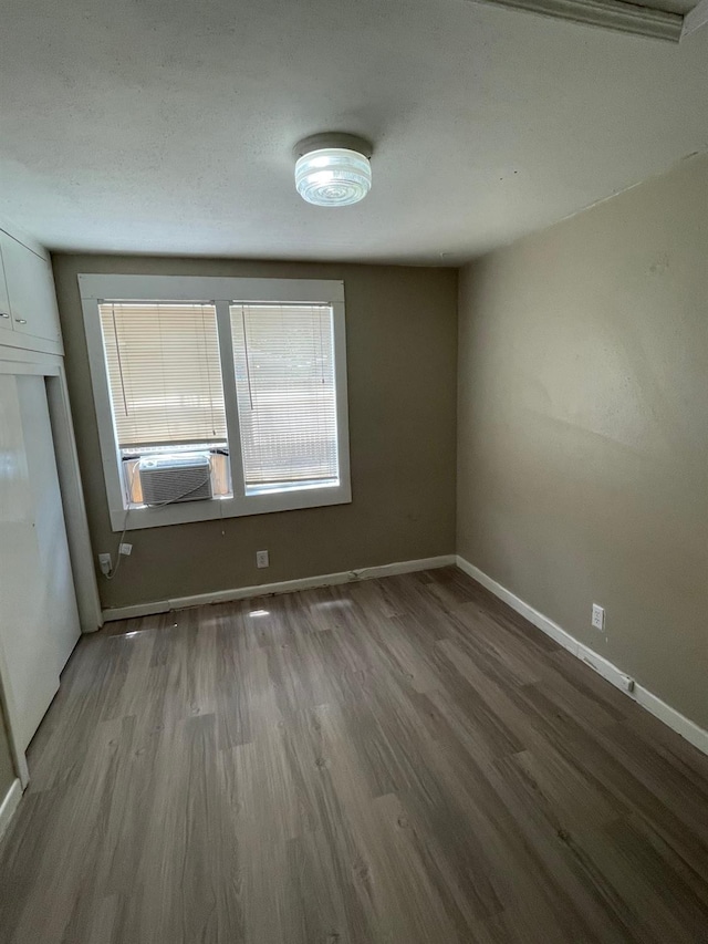 unfurnished room with cooling unit and wood-type flooring