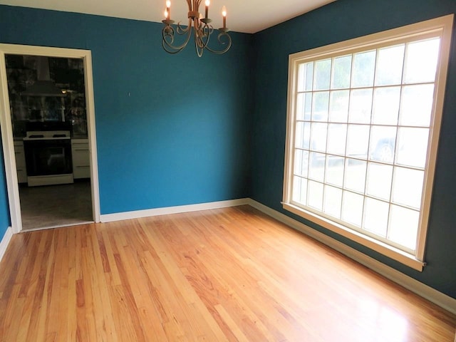 unfurnished room with hardwood / wood-style floors and a chandelier