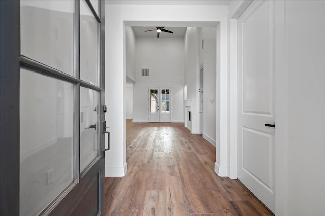 interior space featuring french doors, dark wood-type flooring, and a high ceiling