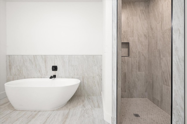 bathroom featuring independent shower and bath and tile walls