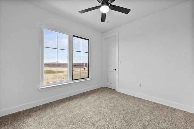 carpeted spare room with ceiling fan