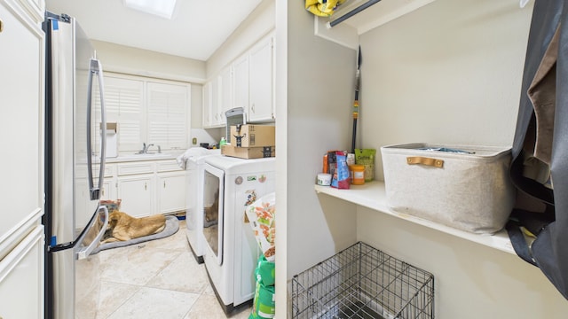 4615 94th St, Lubbock, TX 79424 - laundry room with washer and clothes dryer, cabinet space, and light tile patterned flooring