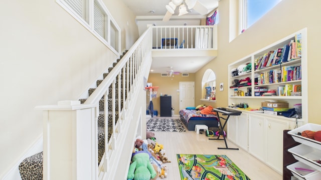 4615 94th St, Lubbock, TX 79424 - rec room with a ceiling fan, light wood finished floors, a towering ceiling, and baseboards