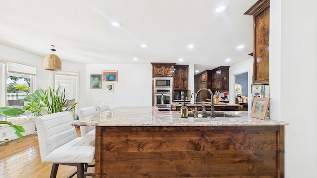 4615 94th St, Lubbock, TX 79424 - kitchen featuring appliances with stainless steel finishes, a sink, light stone counters, recessed lighting, and a peninsula