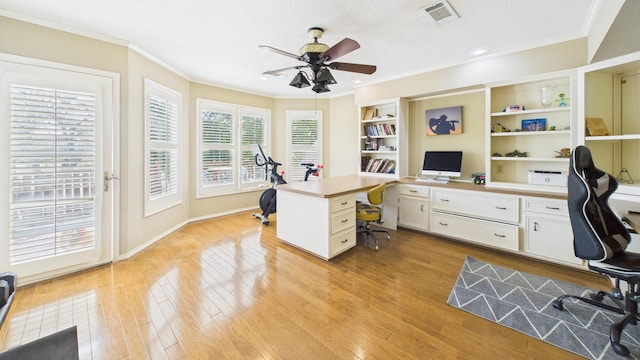 4615 94th St, Lubbock, TX 79424 - office space with ceiling fan, built in desk, ornamental molding, light wood-style flooring, and a textured ceiling