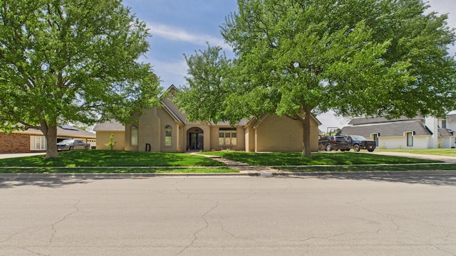 4615 94th St, Lubbock, TX 79424 - view of property hidden behind natural elements with stucco siding, a front lawn, and driveway