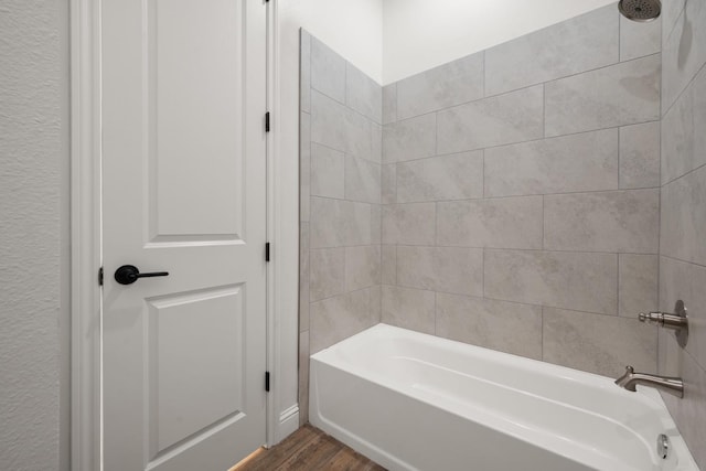 bathroom with tiled shower / bath and wood-type flooring