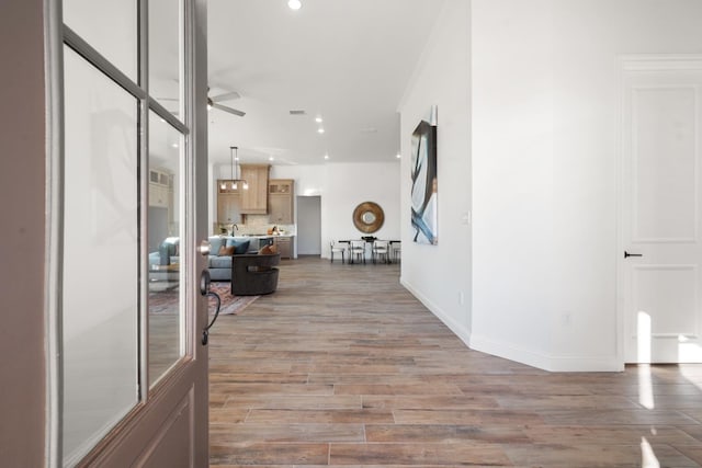 corridor with crown molding and light wood-type flooring