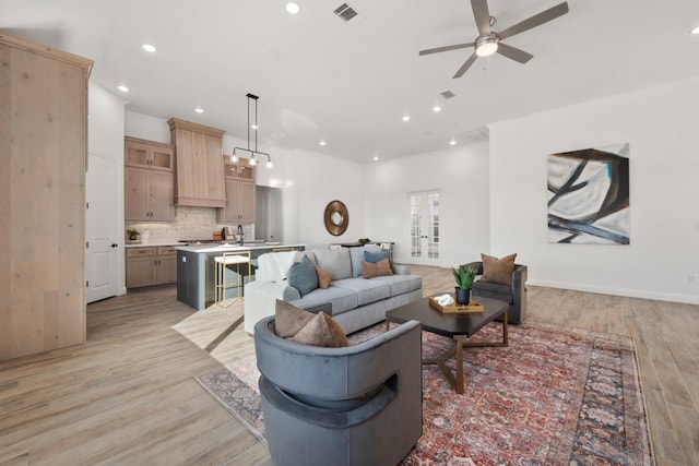 living room with ceiling fan and light hardwood / wood-style floors