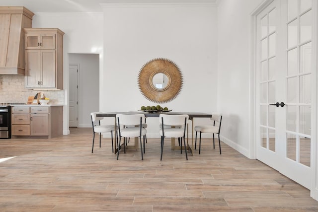 dining area with crown molding and light hardwood / wood-style flooring