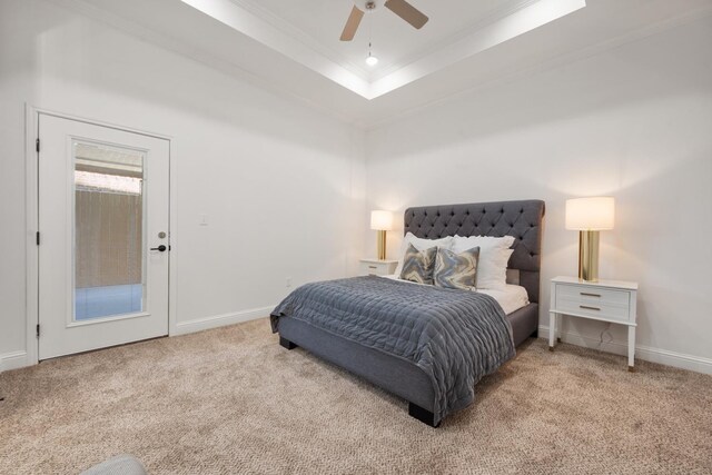 bedroom featuring ornamental molding, light colored carpet, a raised ceiling, and ceiling fan