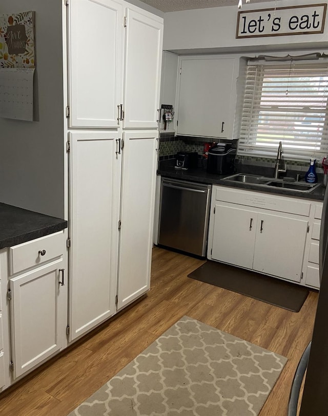 kitchen with dishwasher, sink, light hardwood / wood-style flooring, and white cabinets