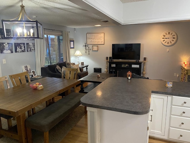 dining space featuring light hardwood / wood-style floors and a textured ceiling