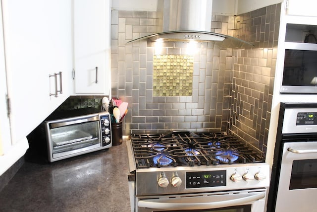 kitchen with appliances with stainless steel finishes, sink, white cabinets, wall chimney exhaust hood, and light hardwood / wood-style flooring