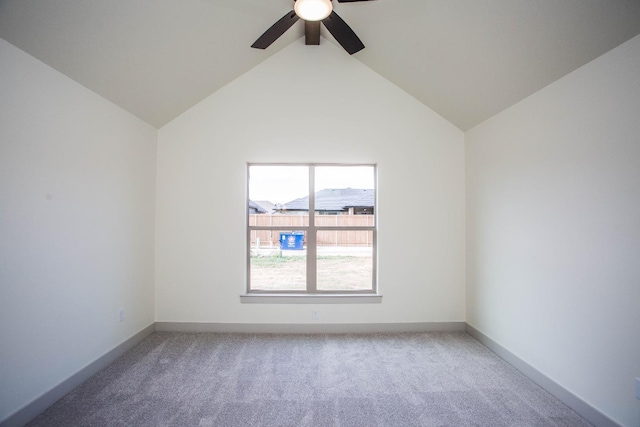 spare room with ceiling fan, vaulted ceiling, and carpet